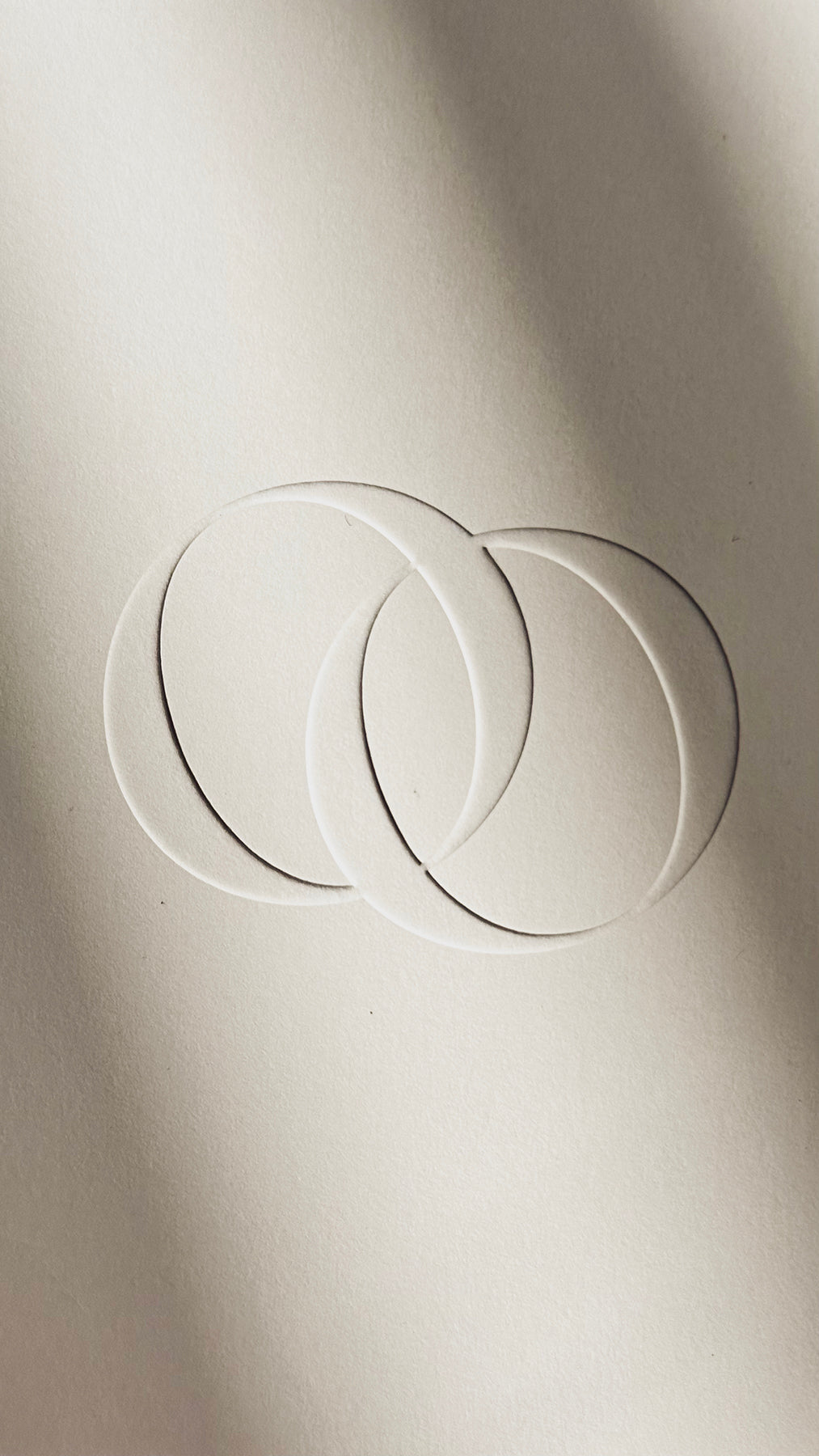 Textured, ivory paper with two intertwined embossed rings